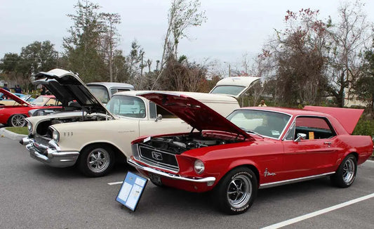 Red Mustang parked at a Cars and Coffee event, surrounded by other vehicles and attendees.